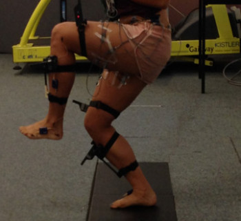 Participant with sEMG electrodes and CodaMotion markers attached to his body during a single leg squat task.